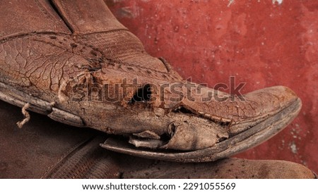 A pair of dirty shoes. Which brings back old memories. Closeup photo of torn part of old shoe.