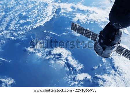 A space satellite above the Earth's surface. Elements of this image furnished NASA.  Royalty-Free Stock Photo #2291065933