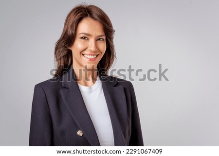 Portait of an attractive businesswoman wearing black blazer and standing at isolated background. Copy space. Royalty-Free Stock Photo #2291067409