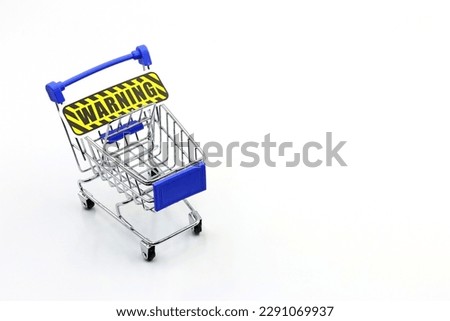 A supermarket trolley with the WARNING sign.  Control of household spending, price increases. Inflation