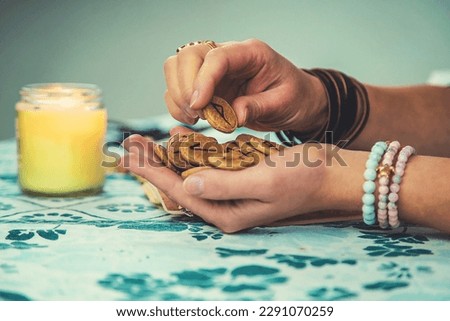 The fortune teller reads with runes in her hands. Selective focus. woman. Royalty-Free Stock Photo #2291070259