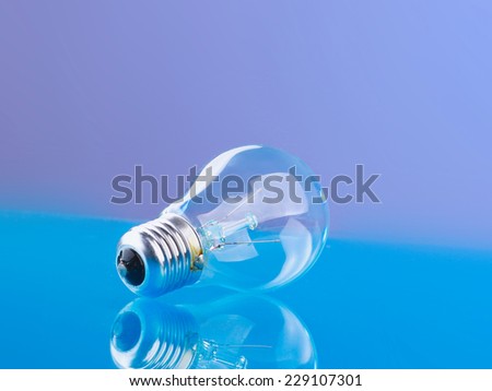 Light bulb isolated on blue glossy background