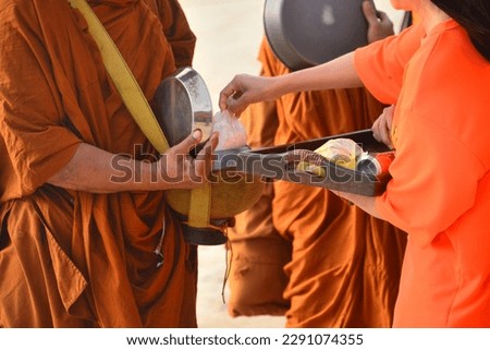 Give alms, Thai Buddhist to do good things make merit by offering food to the monk Royalty-Free Stock Photo #2291074355