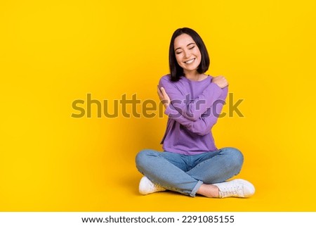 Full size photo of optimistic girl bob hairdo dressed violet shirt pants embrace herself eyes closed isolated on yellow color background Royalty-Free Stock Photo #2291085155