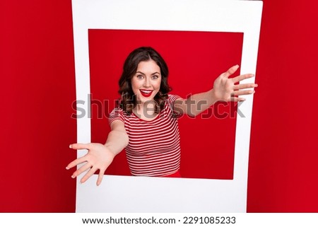 Portrait of gorgeous cheerful person raise opened hands through paper album card invite you isolated on red color background