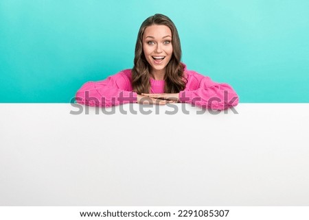 Photo of excited impressed lady dressed knitted pullover hands holding placard empty space isolated teal color background