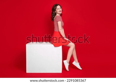 Full length profile portrait of positive adorable person sit podium good mood isolated on bright red color background