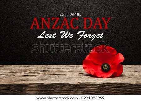 Poppy pin for Anzac Day. Poppy flower on old beautiful high grain, detailed wood on black textured background with text. Royalty-Free Stock Photo #2291088999