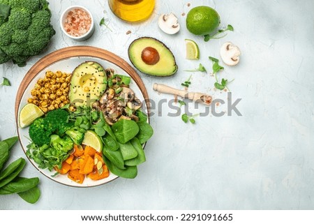 healthy vegan lunch bowl with Avocado, mushrooms, broccoli, spinach, chickpeas, pumpkin on a light background. vegetables salad. Top view. Royalty-Free Stock Photo #2291091665