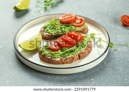 Avocado Toast and tomatoes on light background. Vegetarian food. Vegan menu. place for text, top view. Royalty-Free Stock Photo #2291091779