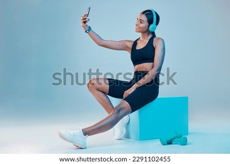 Woman, fitness and selfie in studio with music, wellness or training clothes by background. Gen z model, influencer girl and fashion with streaming, profile picture or exercise for health with smile