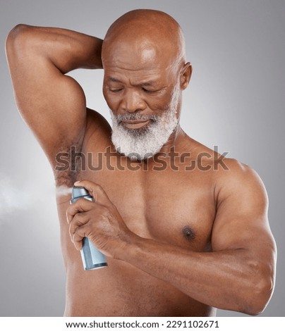 Senior black man, deodorant and armpit for hygiene, grooming or perfume against a gray studio background. Serious elderly African American male spraying cosmetics for fresh fragrance or clean smell