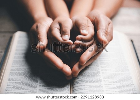 Christian family praying together concept. Child and mother worship God in home. Woman and boy hands praying to god with the bible begging for forgiveness and believe in goodness. Royalty-Free Stock Photo #2291128933