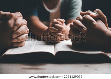 Christian family praying together concept. Child and mother worship God in home. Woman and boy hands praying to god with the bible begging for forgiveness and believe in goodness. Royalty-Free Stock Photo #2291129039