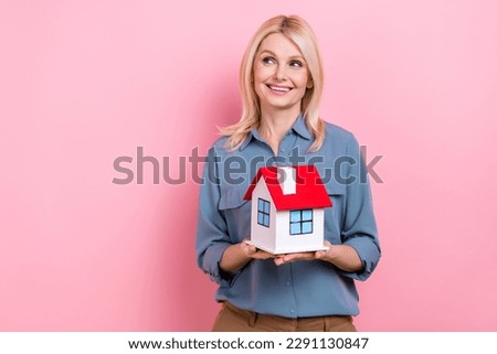 Photo of attractive senior business lady realtor hold cute little house building sell real estate isolated pink color background