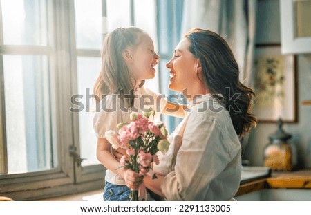 Happy mother's day. Child daughter congratulating her mother and giving her bouquet of flowers. Royalty-Free Stock Photo #2291133005