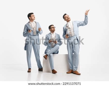 Business planning. Shot of three men, friends wearing old style clothes and discuss things emotionally over white studio background. Concept of comparison of eras, retro, vintage, emotions, friendship