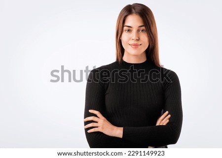 Portrait of smiling woman with arms crossed. Confident young female is having brunette hair. She is in black sweater against white background. Copy space. 