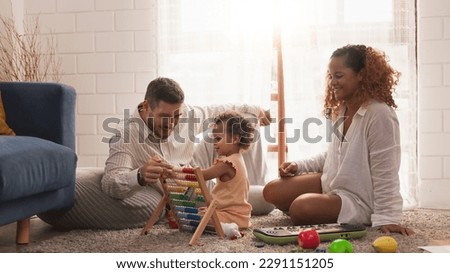 Happy loving young multiracial family African American mother Caucasian father playing with little cute mix race ethnic baby toddler girl at home. Quality time family with an educational didactic toy. Royalty-Free Stock Photo #2291151205