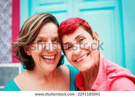 Happy senior women having fun taking selfie picture together outdoor during travel vacation - Focus on center eyes