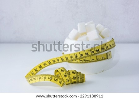 sugar bowl filled with sugar wrapped with measuring tape Royalty-Free Stock Photo #2291188911