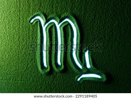 Hand drawing the Scorpio horoscope sign symbol in the Green Sand. Male hand writes the Scorpio horoscope sign symbol on the green sand with white backlight. Top view 4k resolution