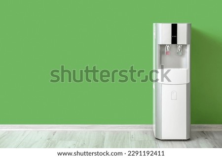 Modern water cooler near green wall Royalty-Free Stock Photo #2291192411