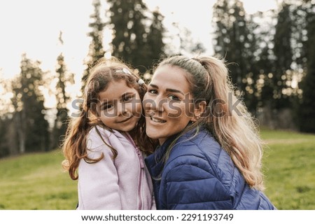 Happy mother and little daughter smiling on camera during trekking day at mountain forest - Family love - Mom day concept