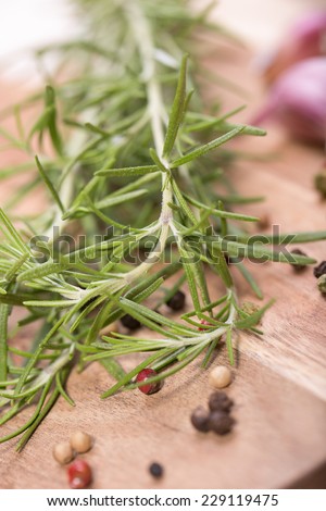 Rosemary bound with pepper and garlic on a wooden board 
