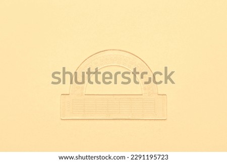 Transparent plastic protractor on beige background