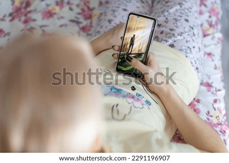 woman lying with smartphone shot with shallow depth of field. addiction to gadgets. High quality photo