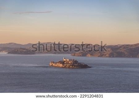 A picture of the Alcatraz Island and the surrounding San Francisco Bay at sunset.