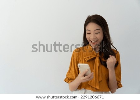 Asian beautiful woman exited surprise face expression . female feels shocked with the phone. exciting smile and happy adorable rejoices. Very enjoy and fun relax time. wow, girl holding smartphone.