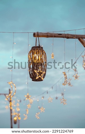 Lighting decor elements at a party outdoors. Cozy lights lanterns and light garland background. selective focus.