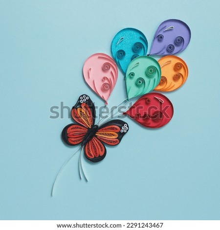 Paper cute butterfly with colorful balloons on blue background. Party elements. Hand made of paper quilling technique. Declaration of love, expression of feelings, congratulations on holidays.