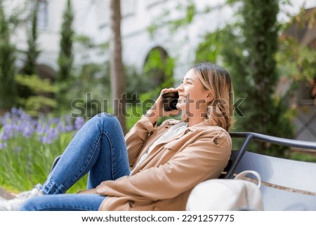 Profile of a teen girl using a mobile phone in a park