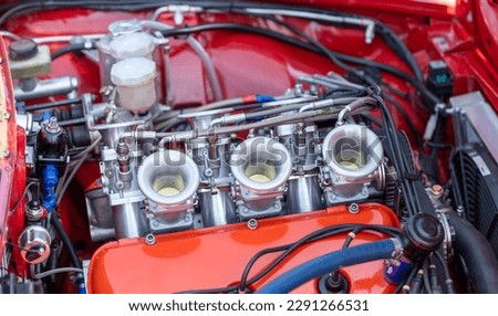 close up of sixties racing car engine with red bodywork