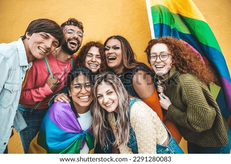 Diverse group of young people celebrating gay pride festival day - Lgbt community concept with guys and girls hugging together outdoors - Multiracial trendy friends standing on a yellow background  Royalty-Free Stock Photo #2291280083