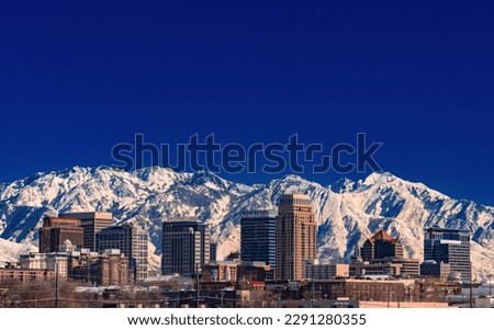 A record-breaking snowpack in the Wasatch Mountains behind the downtown Salt Lake City skyline, Utah. Royalty-Free Stock Photo #2291280355