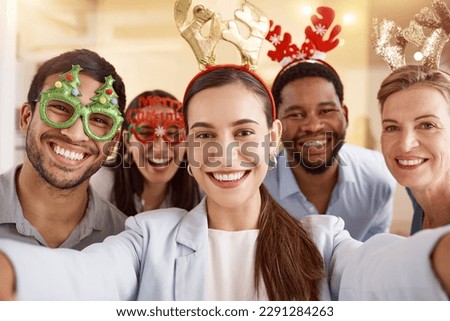 Spreading the festive cheer. Portrait of a group of businesspeople taking selfies together during a Christmas party at work.