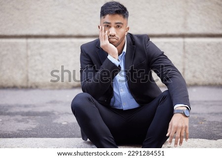 This 9-5 thing is really getting to me. a handsome young businessman sitting and looking bored in the city. Royalty-Free Stock Photo #2291284551