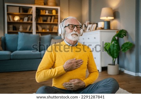 one man mature senior caucasian male using headphones for online guided meditation practicing mindfulness yoga manifestation with eyes closed at home real people self care concept copy space Royalty-Free Stock Photo #2291287841