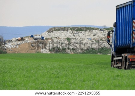 Garbage dump with garbage trucks and an excavator for working with waste Royalty-Free Stock Photo #2291293855