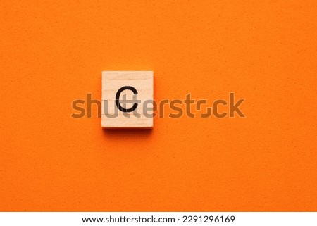 Alphabet letter C on wooden square tile - Orange foamy background