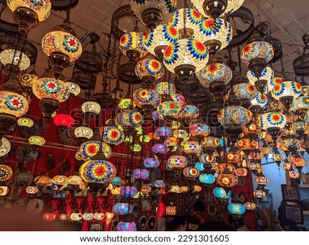 A large display of various colored lights hanging from a ceiling 