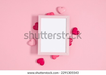 Valentine's day concept. Photo frame, pink hearts on pastel pink background. Love concept. Saint Valentine. Flat lay, top view, copy space