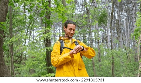 Long hair man with raincoat in forest 
