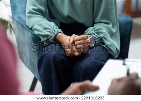Midsection of biracial female patient attending therapy with african american male therapist. Mental health, therapy and counselling. Royalty-Free Stock Photo #2291318233