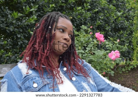 A smiling beautiful woman of color with ruby red color braided hairstyle
