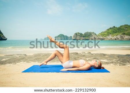 Healthy woman exercising at tropical beach on vacation